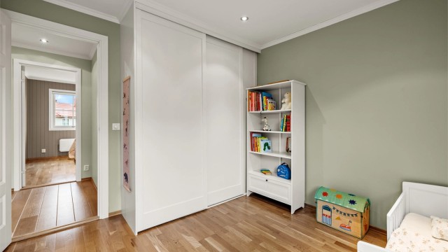 En stor skyvedørsgarderobe gir effektiv oppbevaring på barnerommet.