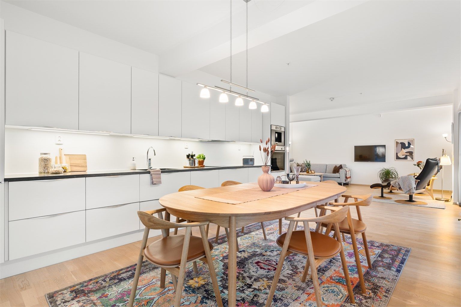 Videre er kjøkkenet innredet med integrert koketopp, stekeovn, oppvaskmaskin, kaffemaskin og kjøleskap.