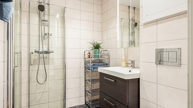 Badet er utstyrt med vegghengt toalett, innfellbare glassdører og downlights i himlingen.