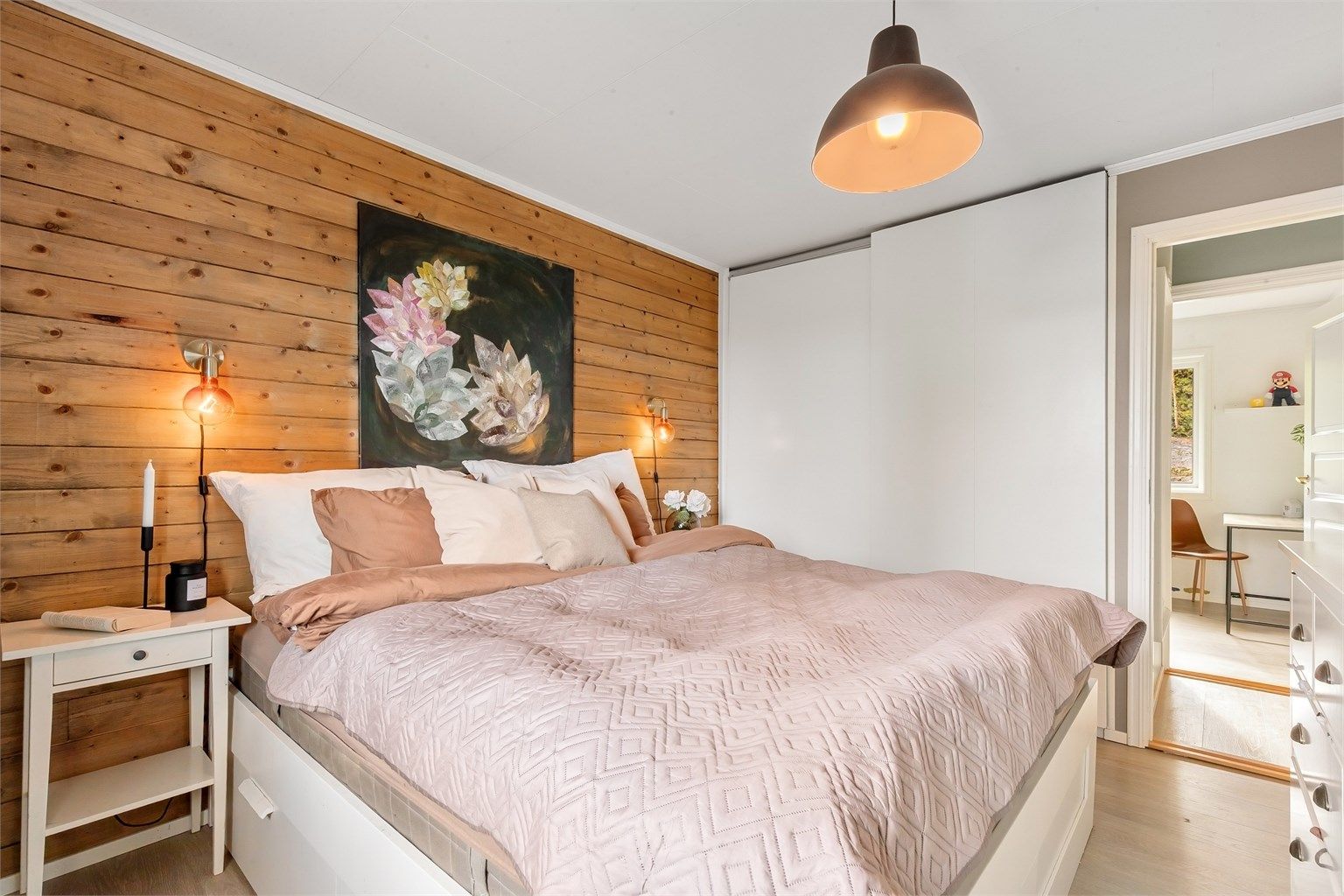 Rommet er utstyrt med en stor skyvedørsgarderobe for effektiv oppbevaring.