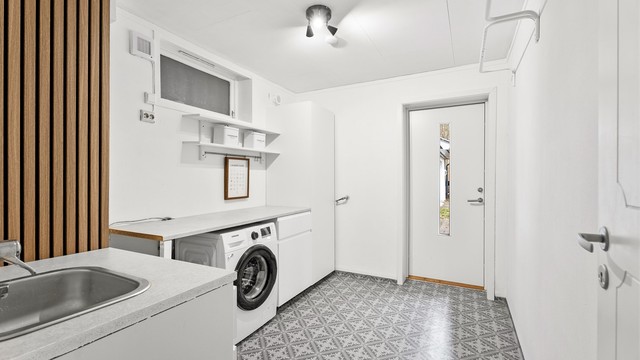Romslig vaskerom med praktisk arbeidsbenk, godt med oppbevaringsplass og vask. Det er også egen inngangsdør til vaskerommet som passer ypperlig med små barn blant annet.