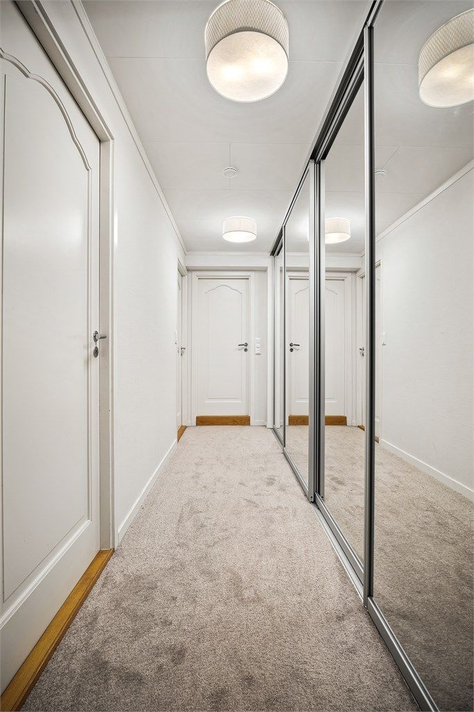 Gang med skyvedørsgarderobe som har speilfronter