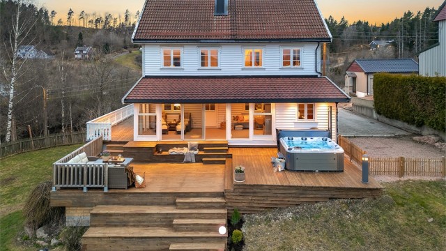 Den store terrassen er bygget i flere nivåer (deler er ikke byggemeldt), noe som skaper naturlige soner for utemøbler, grill og sosiale samlinger.