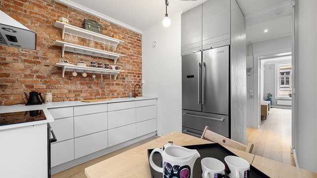 Kjøkkenet er utstyrt med integrert stekeovn, platetopp og oppvaskmaskin. Frittstående kjøleskap med frysedel fra Smeg.