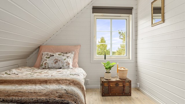 Gavlvinduet slipper inn naturlig lys og vender mot grønne omgivelser.