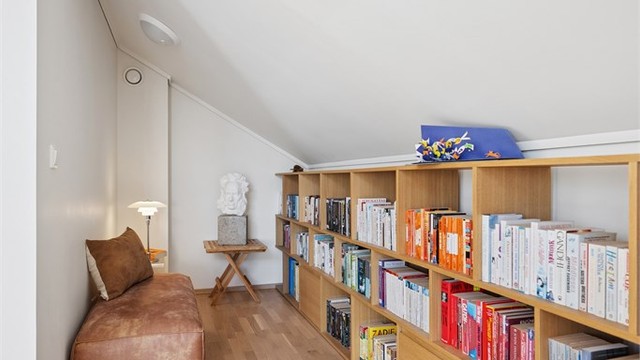 En del av stuen benyttes i dag som bibliotek, her er det god plass til bokhyller og en hyggelig lesekrok.