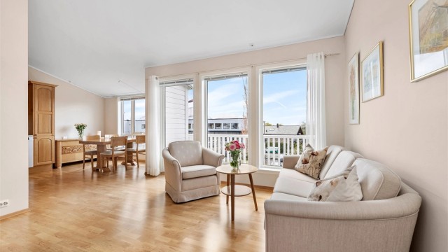 Den romslige stuen har plass til både sofagruppe og spiseplass i tilknytning til kjøkken