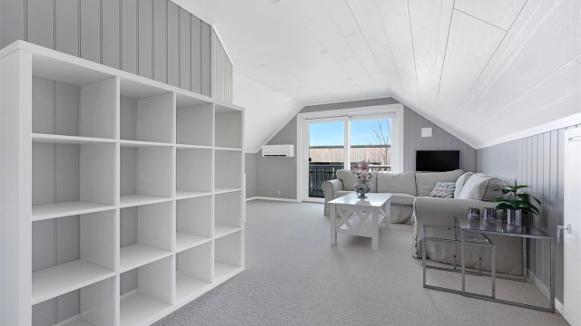 Den romslige loftstuen har heldekkende teppe på gulvet og utgang til balkong via skyvedør.