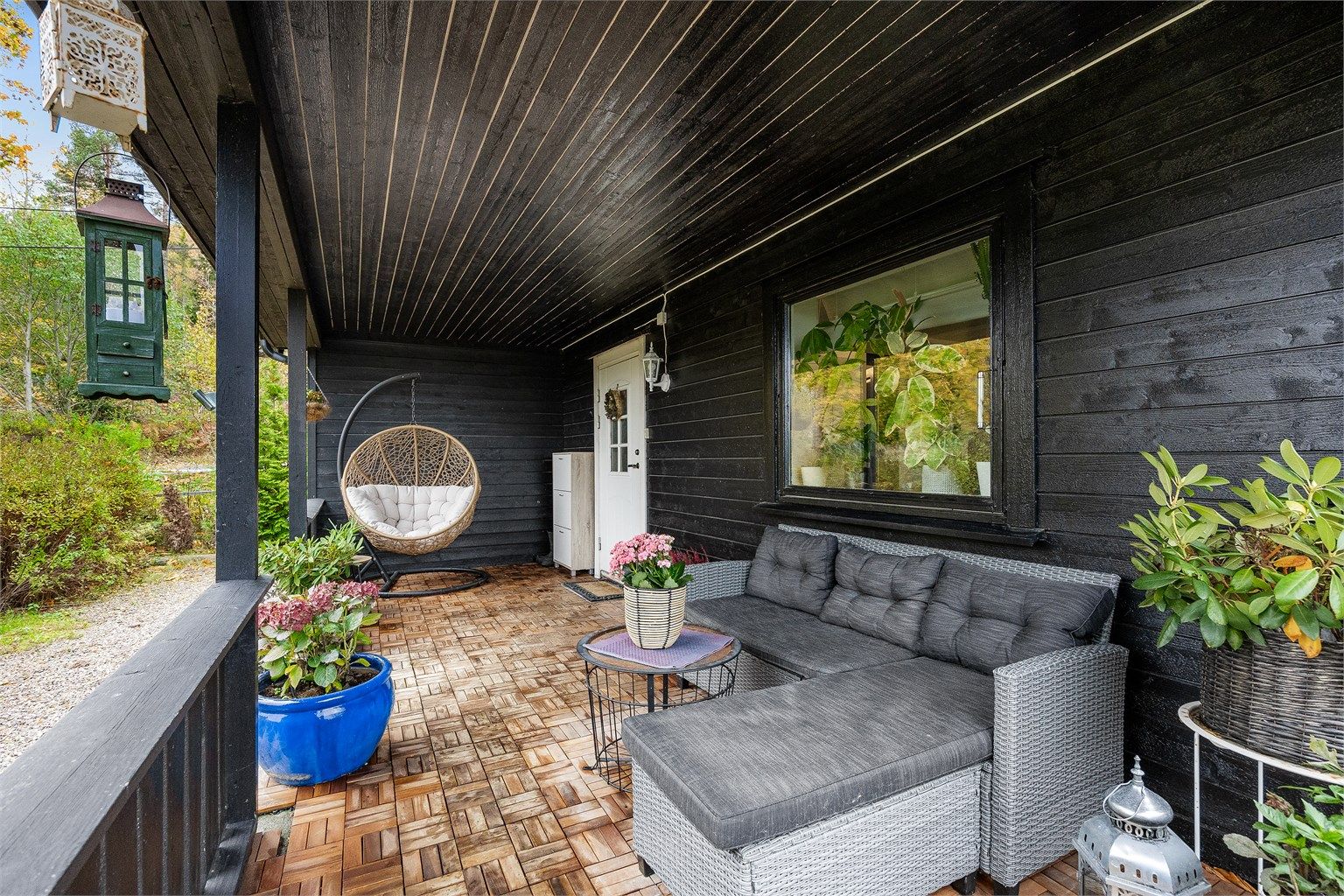 Boligen har et koselig overbygget inngangsparti med rikelig innredningsmuligheter for utemøblement