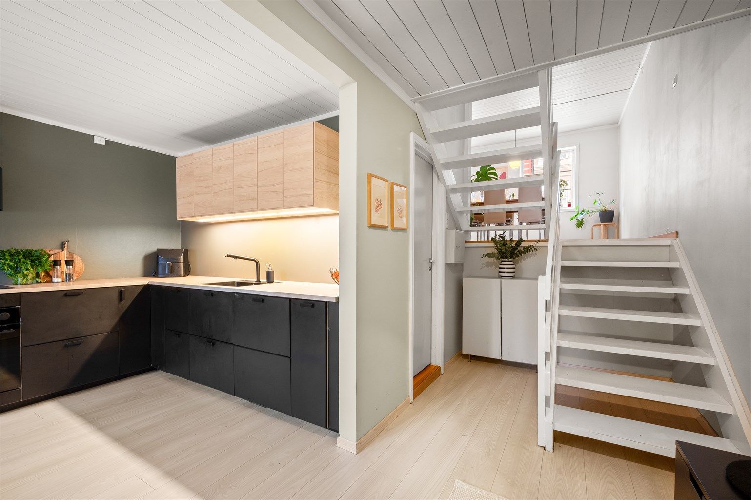 Bak kjøkkenet ligger inngangen til det praktiske vaskerommet. Videre opp trappen ligger spisestuen. 