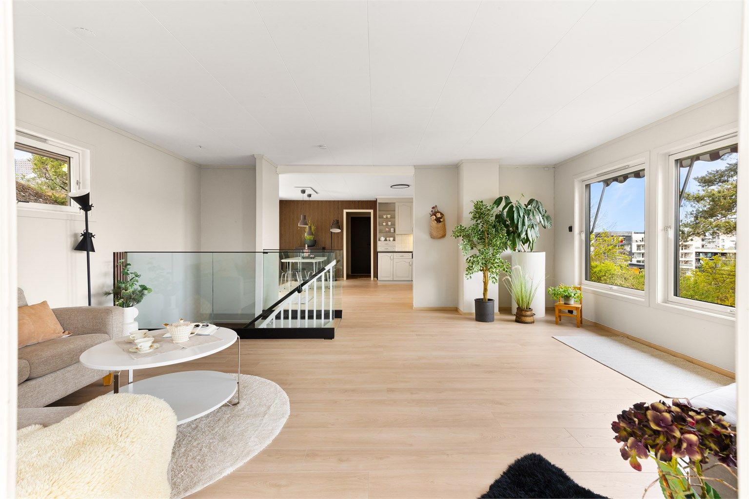 Lys og stilfull stue med store vinduer som rammer inn utsikten