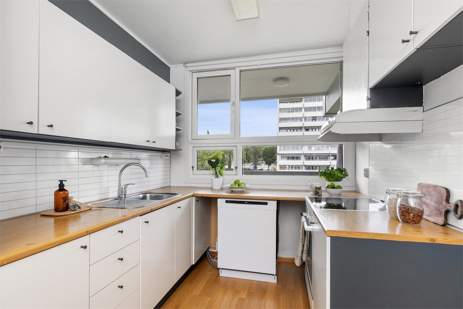 Kjøkkeninnredning med glatte fronter og benkeplate med laminert overflate.