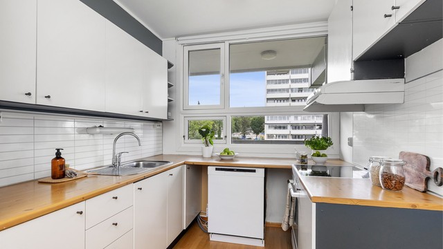 Kjøkkeninnredning med glatte fronter og benkeplate med laminert overflate.
