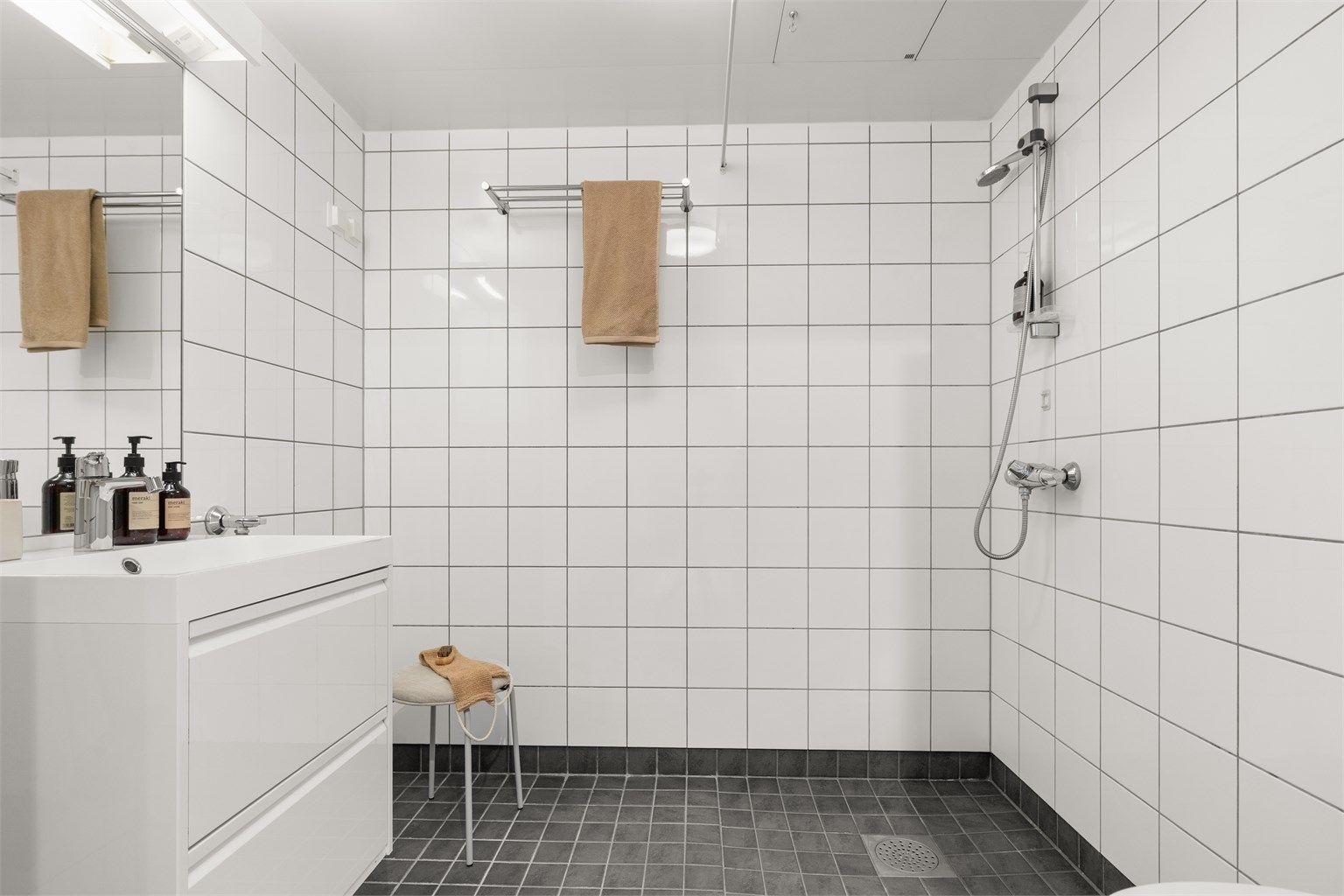 Et pent, praktisk og romslig bad med varmekabler, opplegg for vaskemaskin og ny servantinnredning fra 2026.