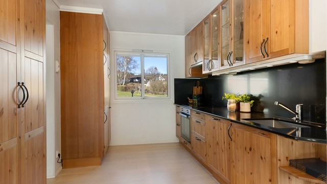 Kjøkkenet har en solid benkeplate i stein og integrerte hvitevarer. Alle hvitevarer medfølger.