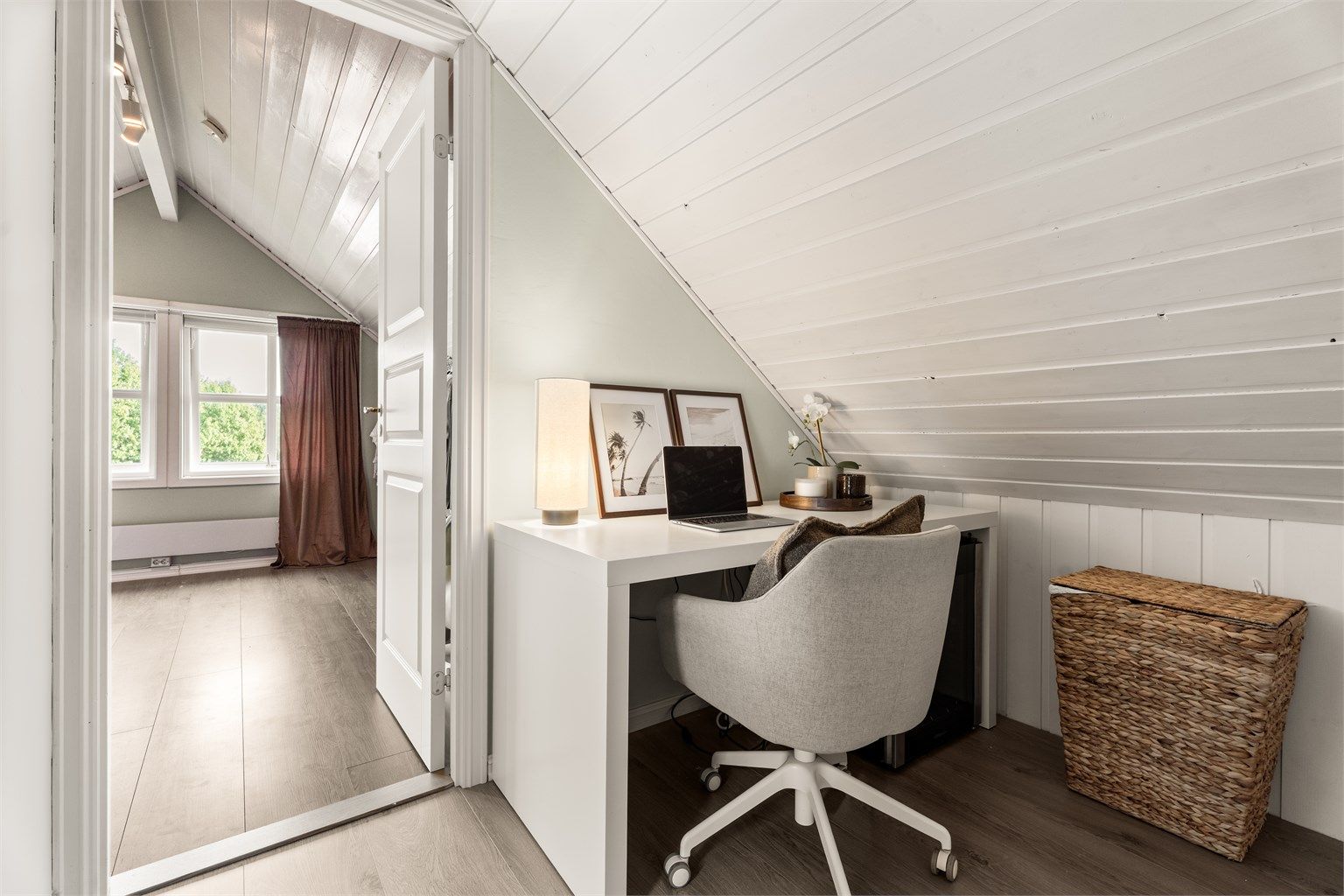 Gang i loftsetasjen med plass til kontorpult under skråtaket.