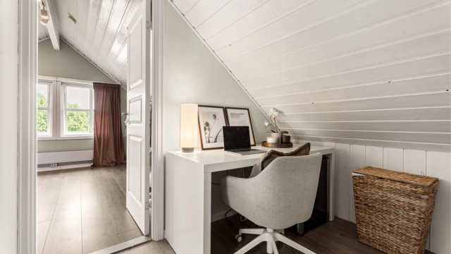 Gang i loftsetasjen med plass til kontorpult under skråtaket.