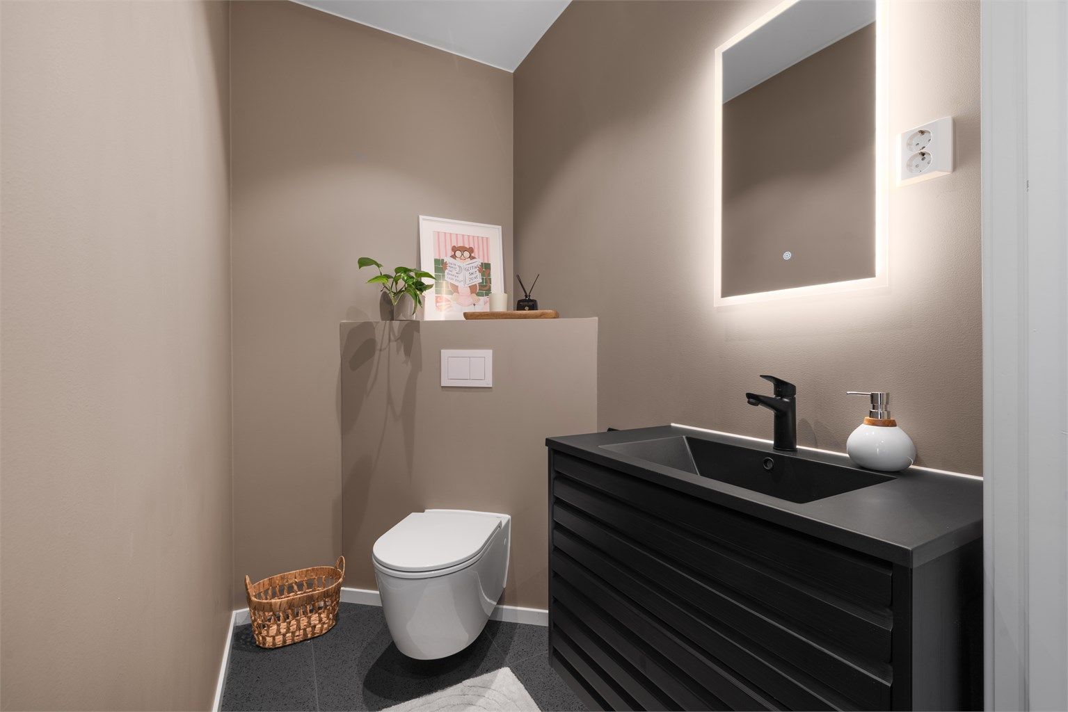 Praktisk toalettrom i første etasje, innredet med vegghengt toalett og servantmøbel med oppbevaring. (Ikke godkjent) 