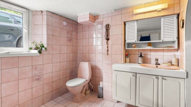 Badet i kjelleren har flislagt gulv med gulvvarme, dusjnisje og gulvstående toalett.