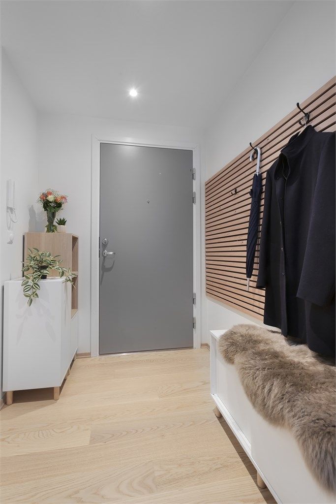 Man kommer inn i en innbydende entré med spilevegg som har knagger for oppheng
