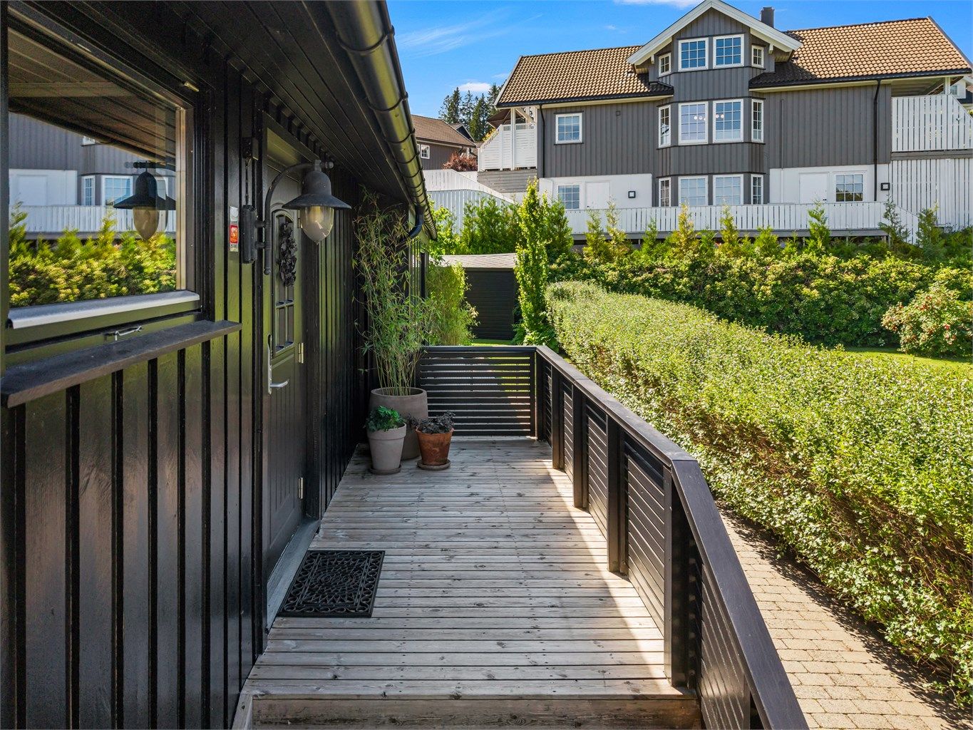 Boligen ønsker deg velkommen med et pent inngangsparti og adkomst via en romslig terrasse som gir et innbydende førsteinntrykk.