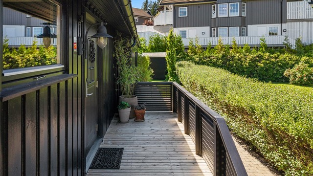 Boligen ønsker deg velkommen med et pent inngangsparti og adkomst via en romslig terrasse som gir et innbydende førsteinntrykk.
