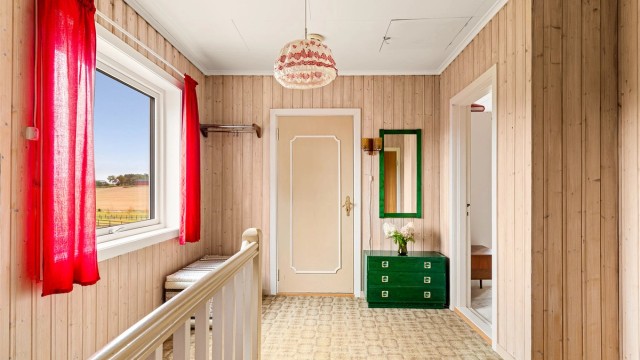 Gang i andre etasje med panelte vegger og tilgang til soverommene.