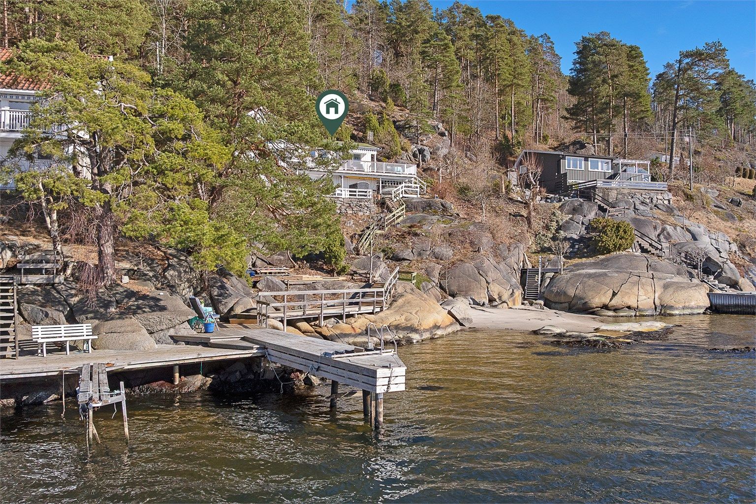 Brygge og sandstrand rett nedenfor hytta.