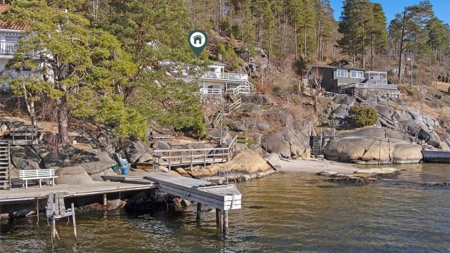 Brygge og sandstrand rett nedenfor hytta.