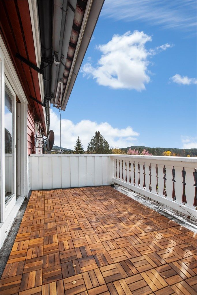 Veranda med terrasseheller på gulvet og utgang via skyvedør fra stuen.