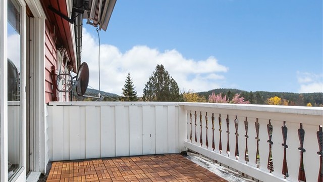 Veranda med terrasseheller på gulvet og utgang via skyvedør fra stuen.