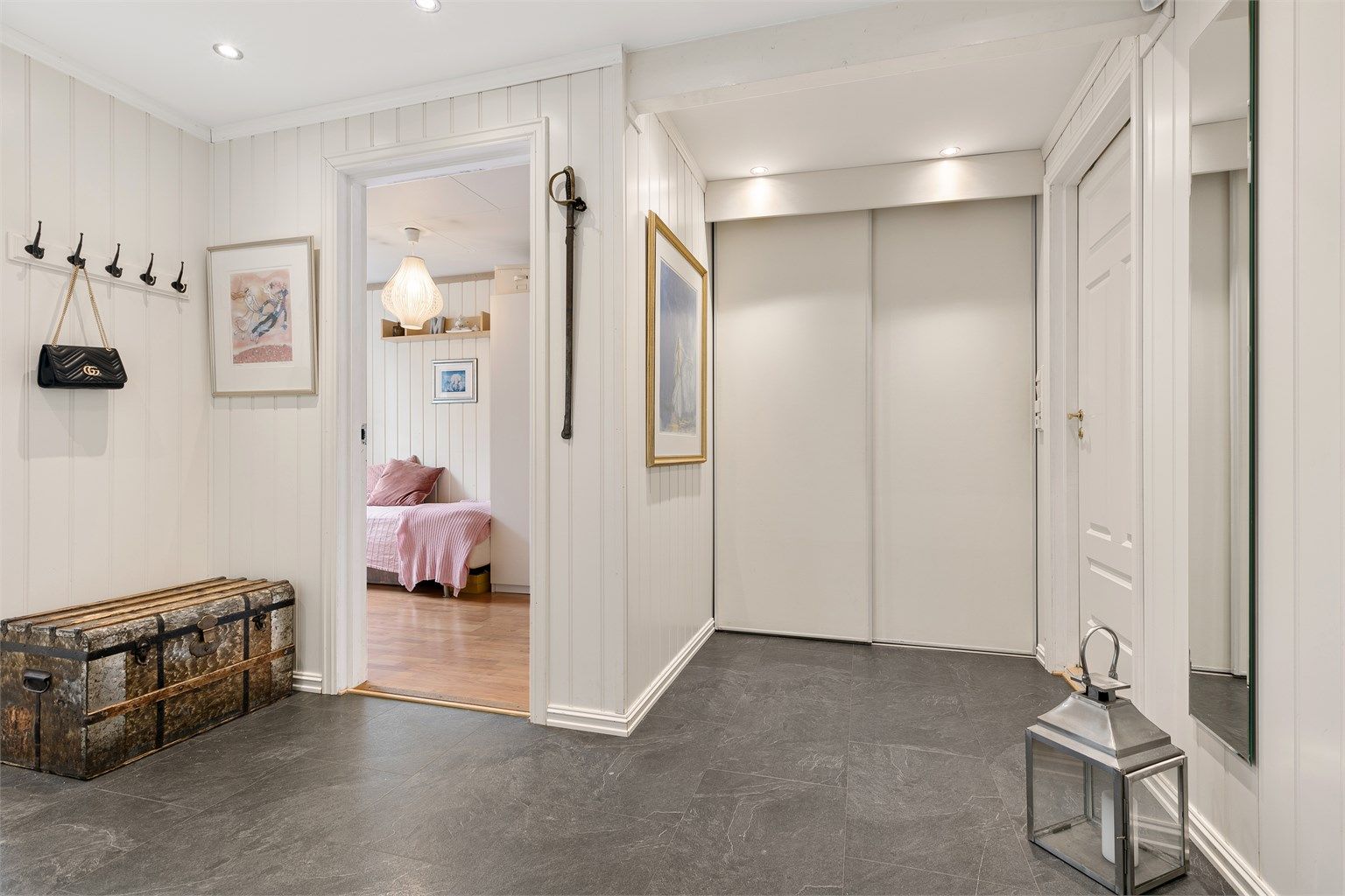 Gangen nede har en dyp skyvedørsgarderobe og et eget skoskap under trappen. 