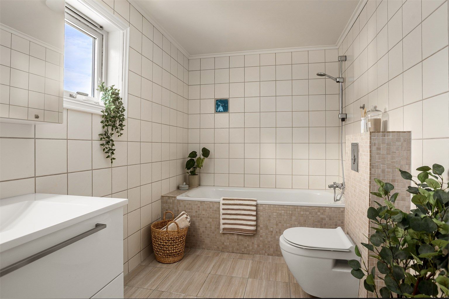 Romslig flislagt bad med gulvvarme. Badet ble i 2018 oppgradet med flis på flis på gulv, samt mosaikkfliser rundt sisterne og badekar