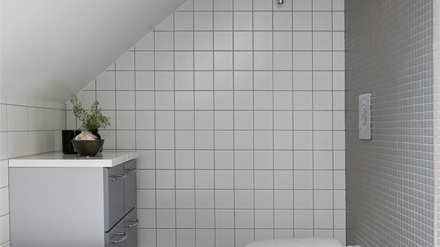 Badet er utstyrt med vegghengt toalett og badekar.