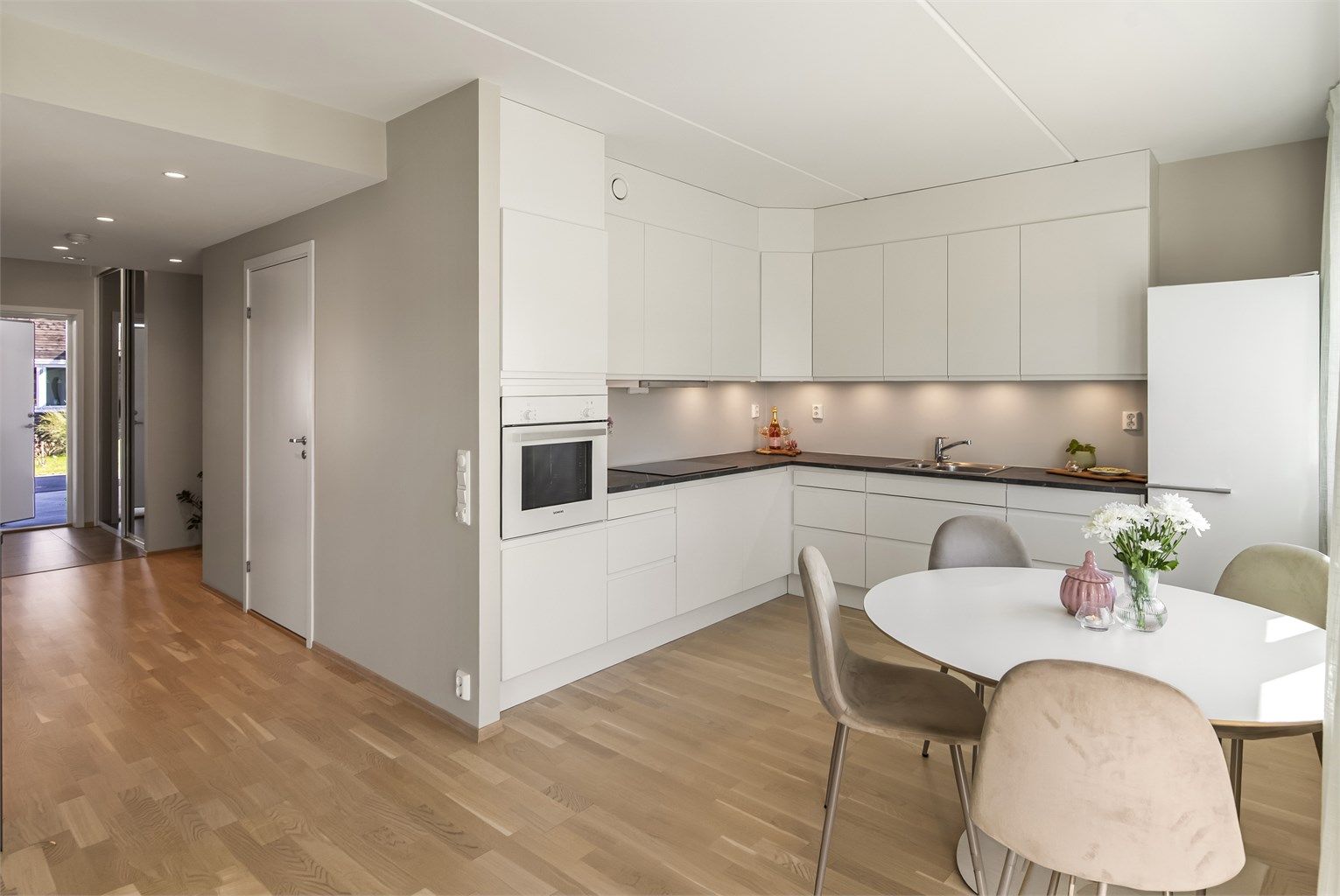 Fra kjøkkenet ser man nedover gangen mot entréen, noe som gir en god romfølelse og oversikt.