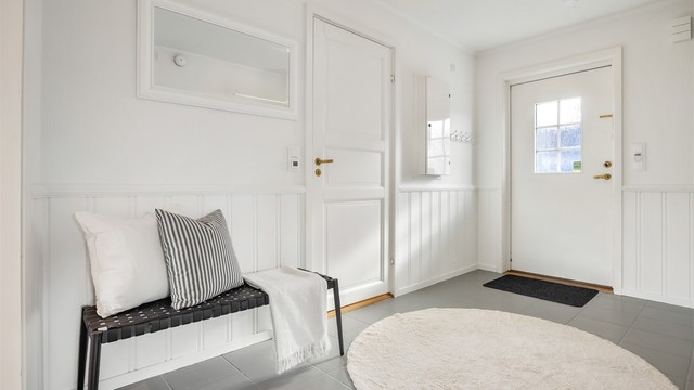 Romslig entré med flislagt gulv og gulvvarme.