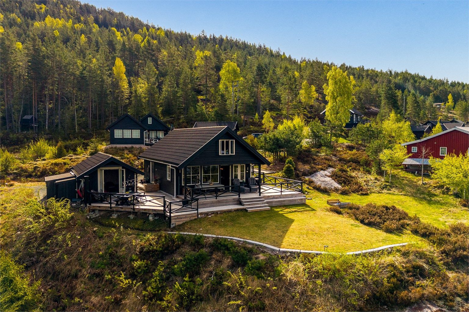 Hytta har flotte uteområder med blant annet en stor terrasse som strekker seg rundt hytta og integrerer annekset på en fin måte.