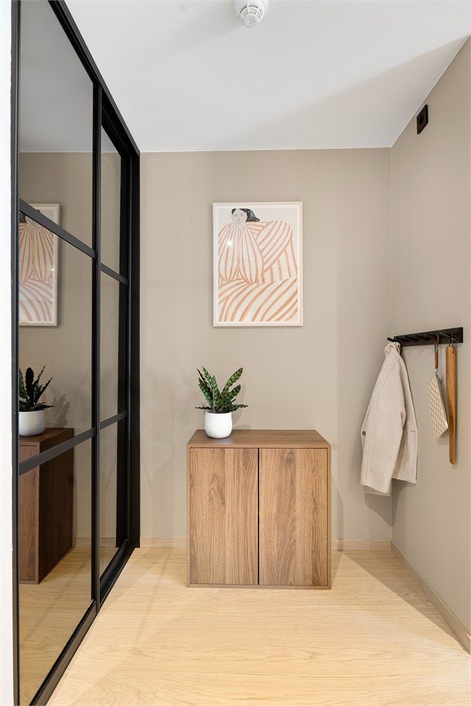 I gangen finner du en praktisk skyvedørsgarderobe med plass til yttertøy og ellers plass til skjenk, knagg m.m..