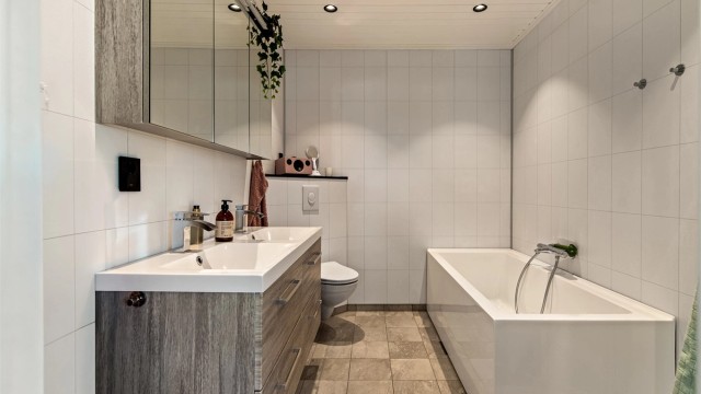 Bad i 1. etasje oppgradert i 2020 med heldekkende dobbeltservant, badekar og gulvvarme.