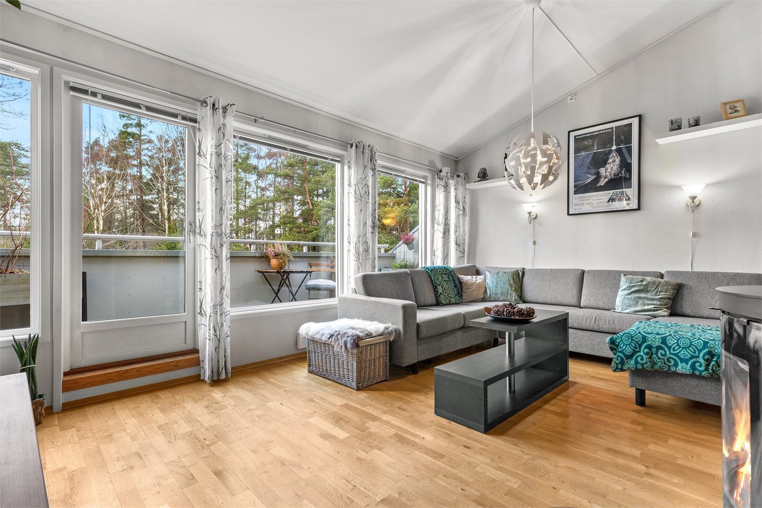 Stue med store vindusflater mot balkongen og skogen