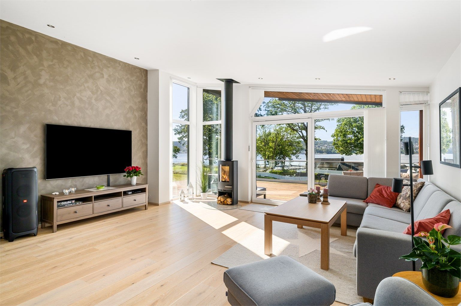 Sofakroken er plassert ut mot terrassen. De store vindusflatene gir godt lys. Fondveggen er malt med sjatteringer, et kult interiørinnslag.