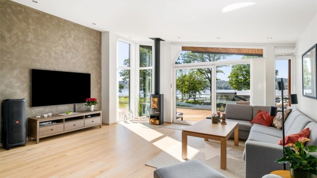 Sofakroken er plassert ut mot terrassen. De store vindusflatene gir godt lys. Fondveggen er malt med sjatteringer, et kult interiørinnslag.