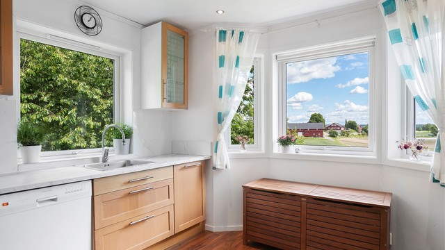 Kjøkkeninnredningen er fra byggeår, med profilerte fronter og laminat benkeplate.