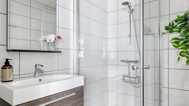 Badet har flislagte overflater og moderne innredning.