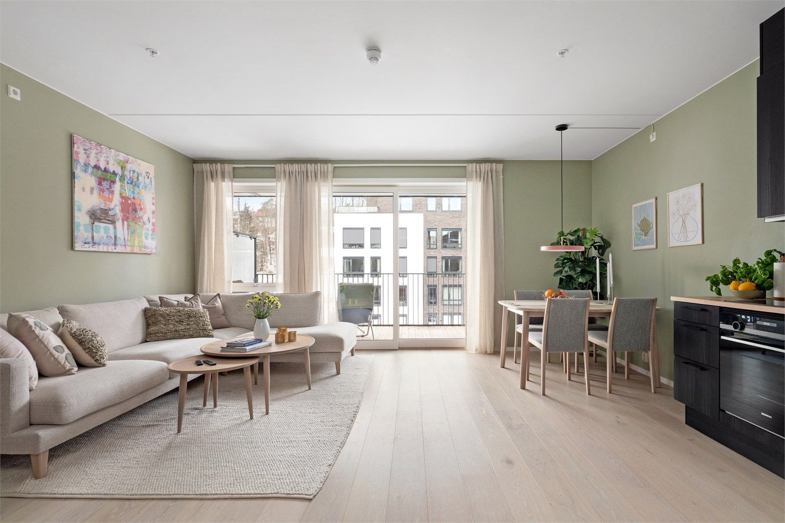 Stuen har store vindusflater som slipper inn godt med naturlig dagslys, kombinasjonen med det lyse 1-stavs parkettgulvet og de duse grønnmalte veggene gir god romfølelse