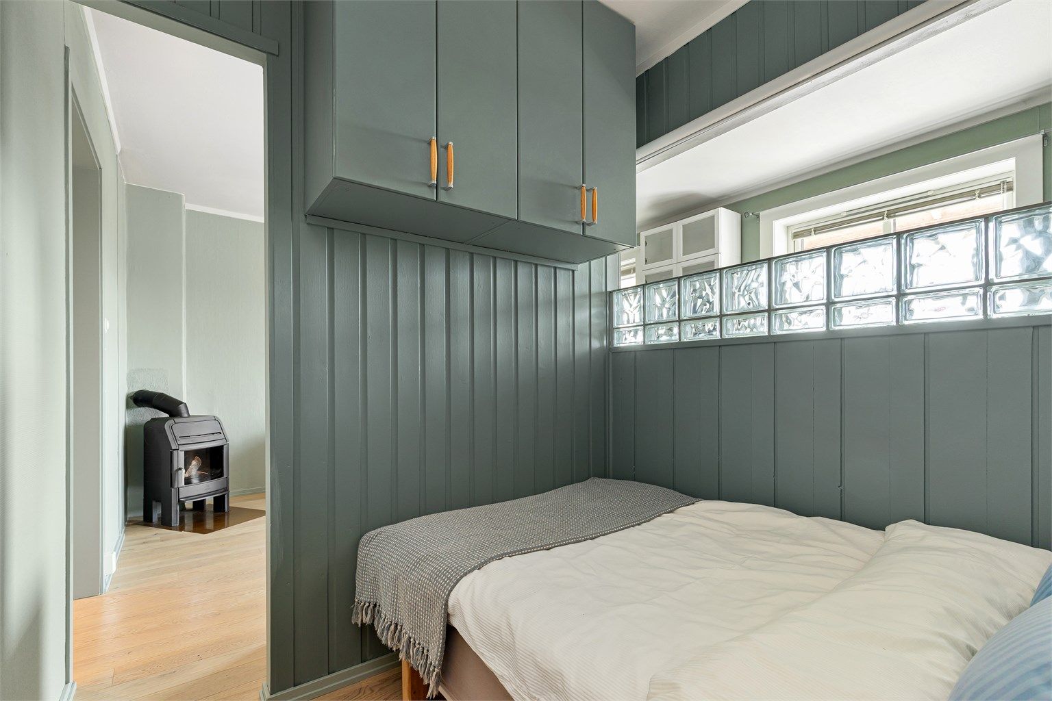 Halvveggen i alkoven gir rommet et fint naturlig lys. Det er montert rullegardin som gjør det mulig å blokkere sollyset inn i alkoven