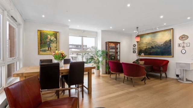 Stuen har god plass til både spisebord og sofagruppe, med gjennomgående parkett på gulvet.