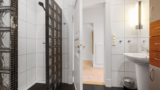 Badet har også en egen dusjnisje med glassvegg.