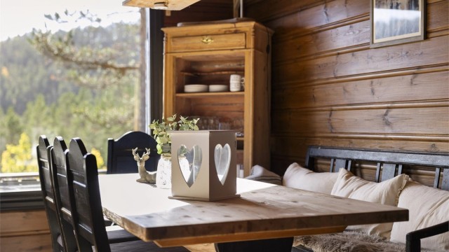 Spisebordet har naturlig lysinnslipp fra vinduet mot skogen.