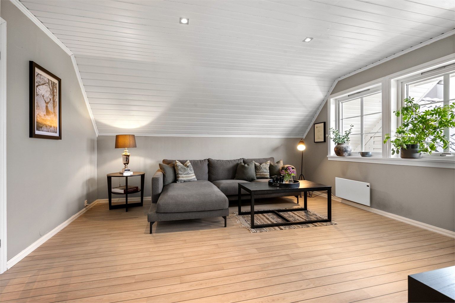Loftstuen har panel i taket og laminat på gulvet.